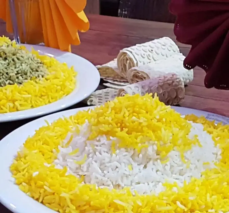 برنج زعفرانی، سفید و سبزی پلو در کنار نان داغ، سرو شده در کافه قلیان و سفره خانه سنتی کولاک. غذای ایرانی.