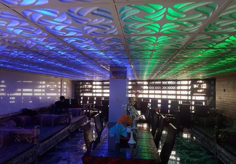 دکوراسیون داخلی کافه قلیان و سفره خانه سنتی کولاک با سقف نورپردازی شده رنگارنگ و مبلمان سنتی راحت، فضایی آرامش‌بخش.