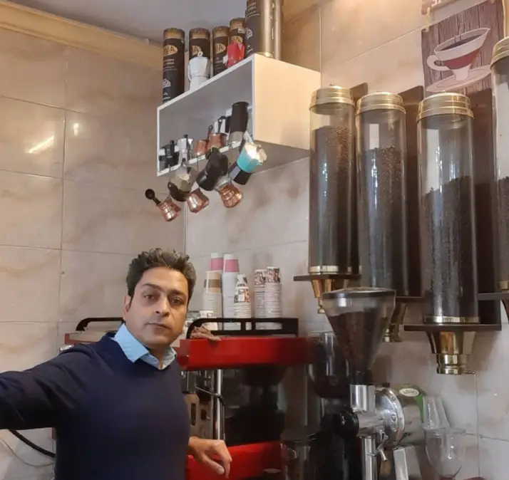 تصویری از باریستا ماهر کافه آرمان در محیطی دنج و مدرن، آماده سرو انواع قهوه تازه با استفاده از بهترین دانه قهوه و تجهیزات پیشرفته.