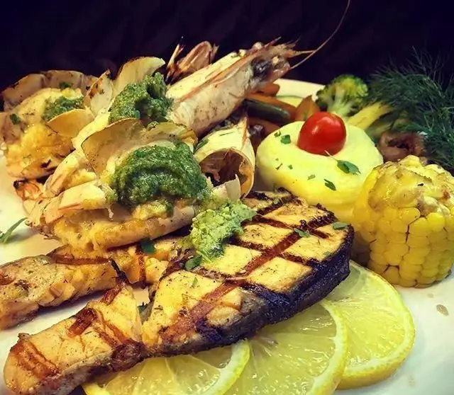 پلاتر غذای دریایی لوکس کافی شاپ میلان شامل ماهی گریل، میگو، پوره سیب زمینی، ذرت و سبزیجات تازه، انتخابی عالی برای شام.