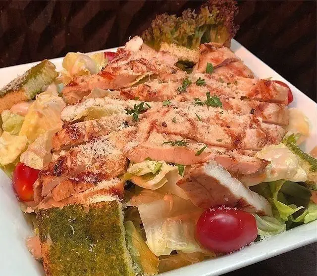 سالاد سزار ویژه کافی شاپ میلان با سینه مرغ گریل شده، نان تست پستو، گوجه گیلاسی و پنیر پارمزان، یک انتخاب سالم و لذیذ.