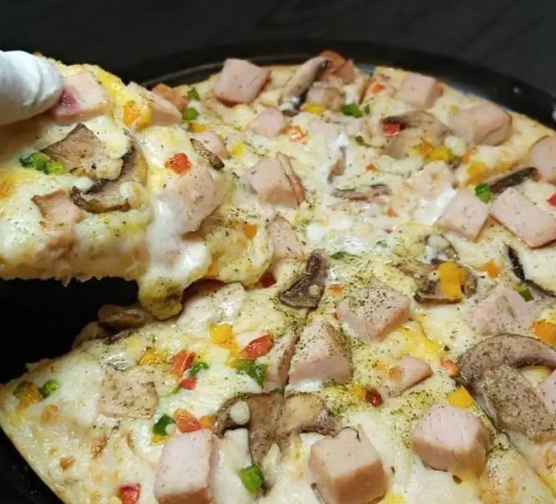 پیتزا سس سفید دیدومک با تکه‌های گوشت، قارچ، فلفل دلمه‌ای رنگی و پنیر کشسان. یک اسلایس خوشمزه از کافه و فست فود دیدومک.