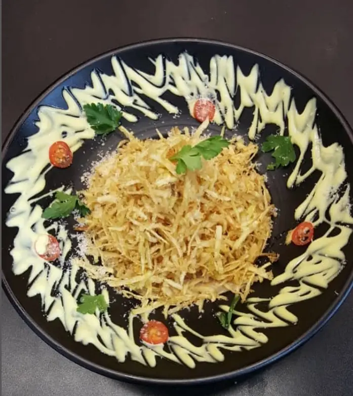 بشقاب سیب زمینی سرخ شده کریسپی و لذیذ همراه با سس مخصوص، گوجه گیلاسی و جعفری تازه، کافه و فست فود دیدومک