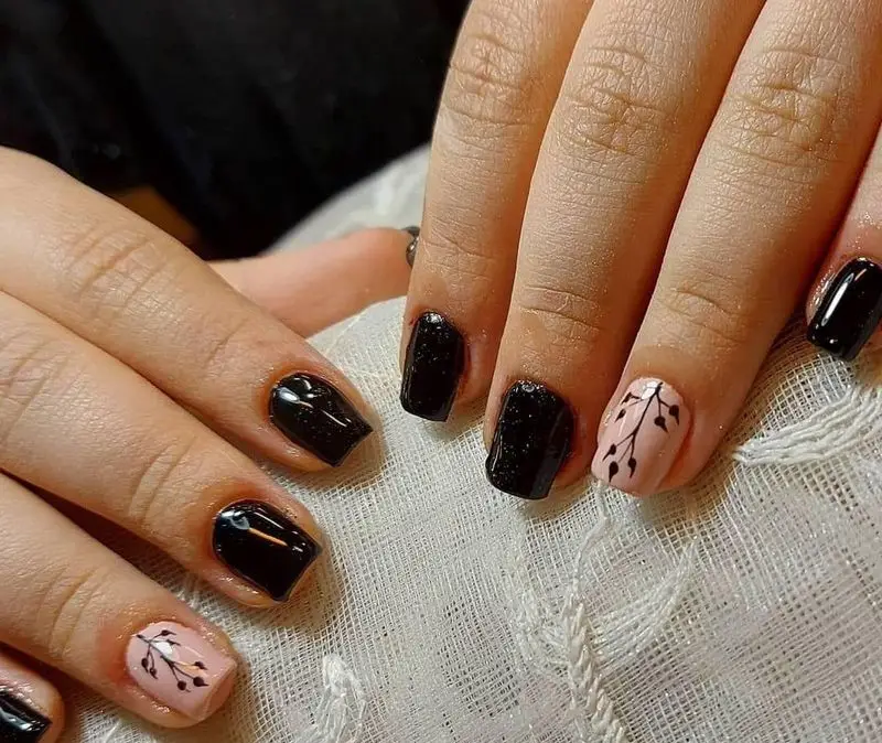 نمونه کار طراحی ناخن خاص: ژلیش مشکی براق و اکلیلی با طرح برگ روی ناخن هلویی، ارائه شده توسط خدمات تخصصی ناخن حدیث.