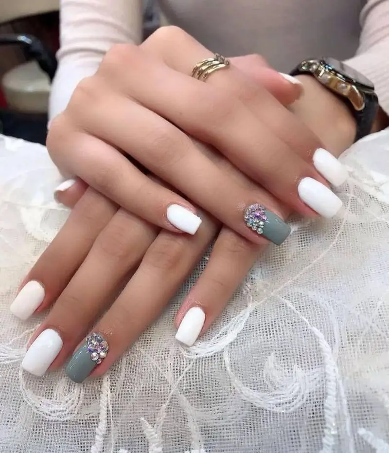 نمونه کار کاشت و طراحی ناخن با لاک ژل سفید و طوسی به همراه نگینهای درخشان و ظریف در سالن خدمات تخصصی ناخن حدیث