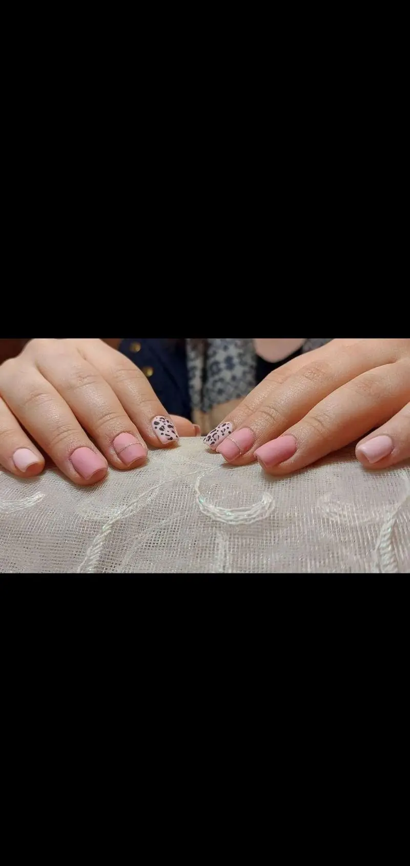 کاشت ناخن صورتی ملایم مات همراه با طراحی پلنگی سیاه و سفید و خطوط نقرهای، نمونه کار سالن خدمات تخصصی ناخن حدیث روی پارچه توری
