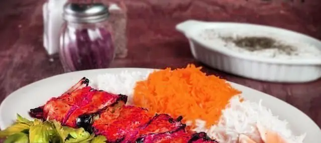 تصویری جذاب از کباب مرغ یا ماهی لذیذ به همراه پلو سفید و پلو نارنجی، غذای اصیل و با کیفیت رستوران ایرانی گل یخ.