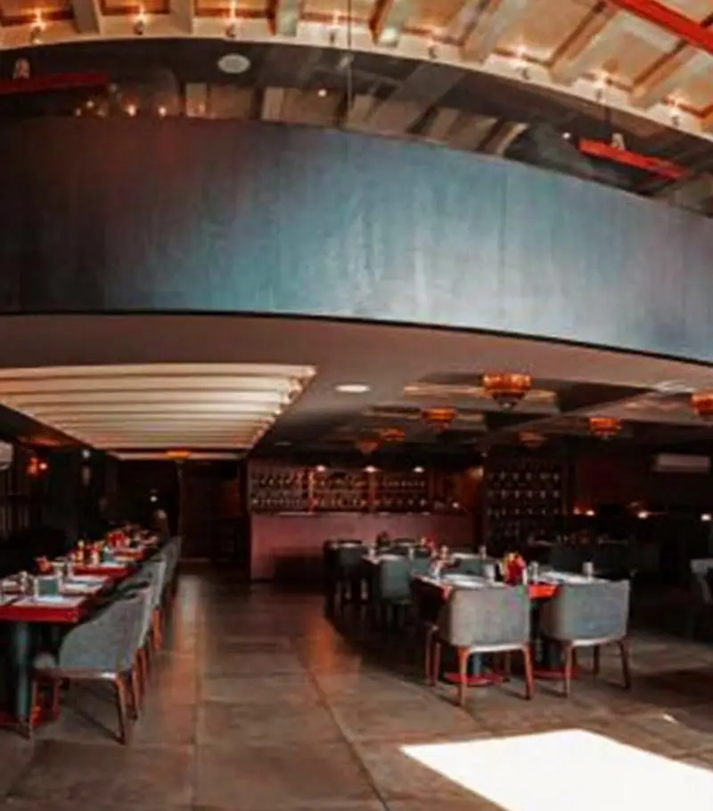 نمایی از دکوراسیون داخلی لوکس رستوران ایتالیایی مازتی، شامل میزهای غذاخوری چیدمان شده و بخش بار، محیطی آرام و دلپذیر.