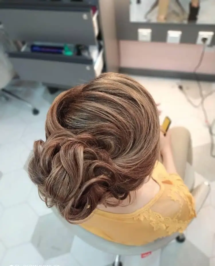 مدل شینیون موی بسته و مجلسی زنانه با هایلایتهای روشن و زیبا در سالن آرایشگاه مناسب برای موهای بلند عروس و همراه
