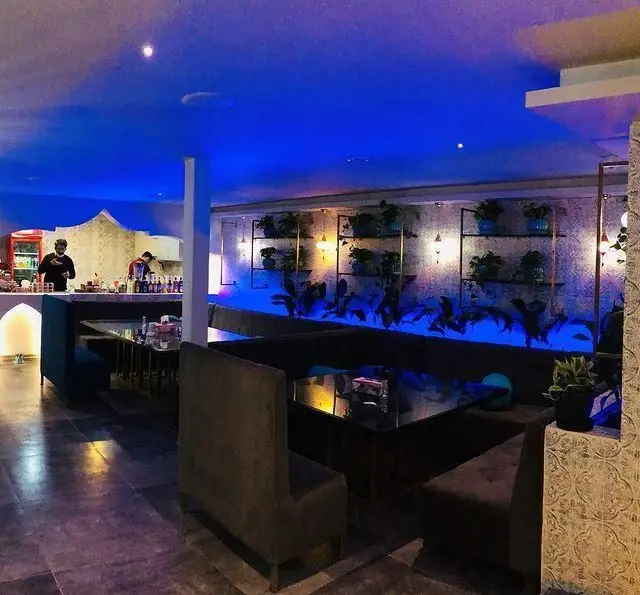 فضای داخلی دلنشین کافه رستوران الخلیفه با نورپردازی آبی آرامش‌بخش، دکوراسیون مدرن، میز و صندلی‌های راحت و کانتر سرویس‌دهی.