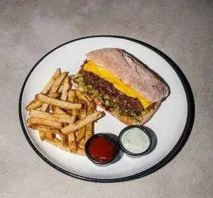 ساندویچ مخصوص رستوران فرسکو با گوشت، پنیر و خیارشور، همراه سیب زمینی سرخ کرده و سس. انتخابی عالی برای ناهار.