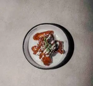 بال مرغ سرخ شده ترد و آبدار با سس مخصوص و دیزاین خلاقانه رستوران فرسکو، انتخابی عالی برای دوستداران غذای خوشمزه.