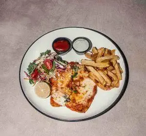 غذای اصلی رستوران فرسکو: شنیتسل مرغ پنیری با سیب زمینی سرخ کرده، سالاد تازه، لیمو و دو نوع سس خوش طعم.