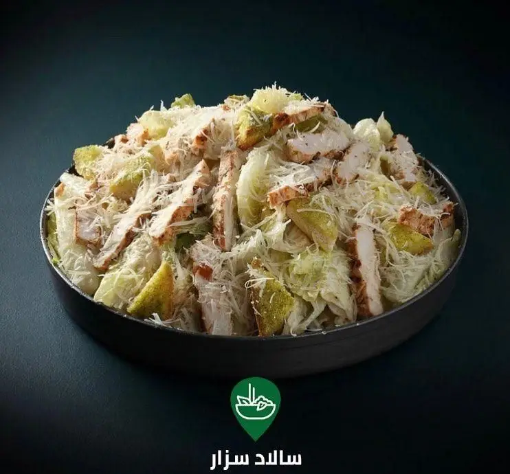 عکس سالاد سزار لذیذ کافه لوکال ولنجک شامل مرغ گریل، کاهوی تازه، پنیر پارمزان فراوان و نان تست.