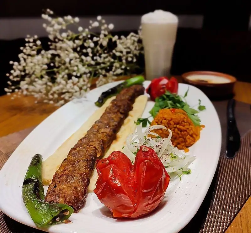 کباب آدانا سنتی رستوران ترکی تورکواز: کباب، گوجه کبابی، فلفل، برنج بلغور، پیاز و دوغ. تجربه‌ای اصیل از غذای ترکی.