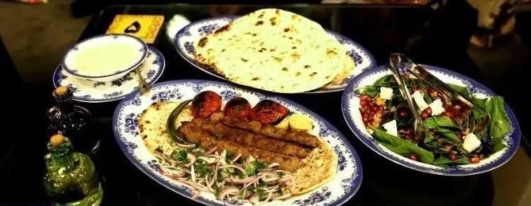 سفره‌ای چشم‌نواز از کباب کوبیده، نان تازه، سالاد انار و پنیر و پیش‌غذاهای خوشمزه در کافی شاپ ایل. تجربه‌ای اصیل از غذای ایرانی.