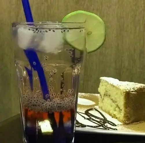 کافه رستوران آدا: نوشیدنی لذیذ و خنک تخم شربتی با برش لیمو و یخ، به همراه کیک عصرانه و دیزاین شکلات.