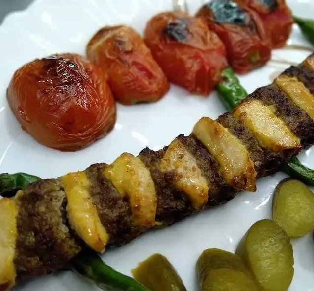 کباب کوبیده لذیذ با دنبه، گوجه و فلفل کبابی همراه خیارشور در کبابی منیریه. بهترین غذای اصیل ایرانی.