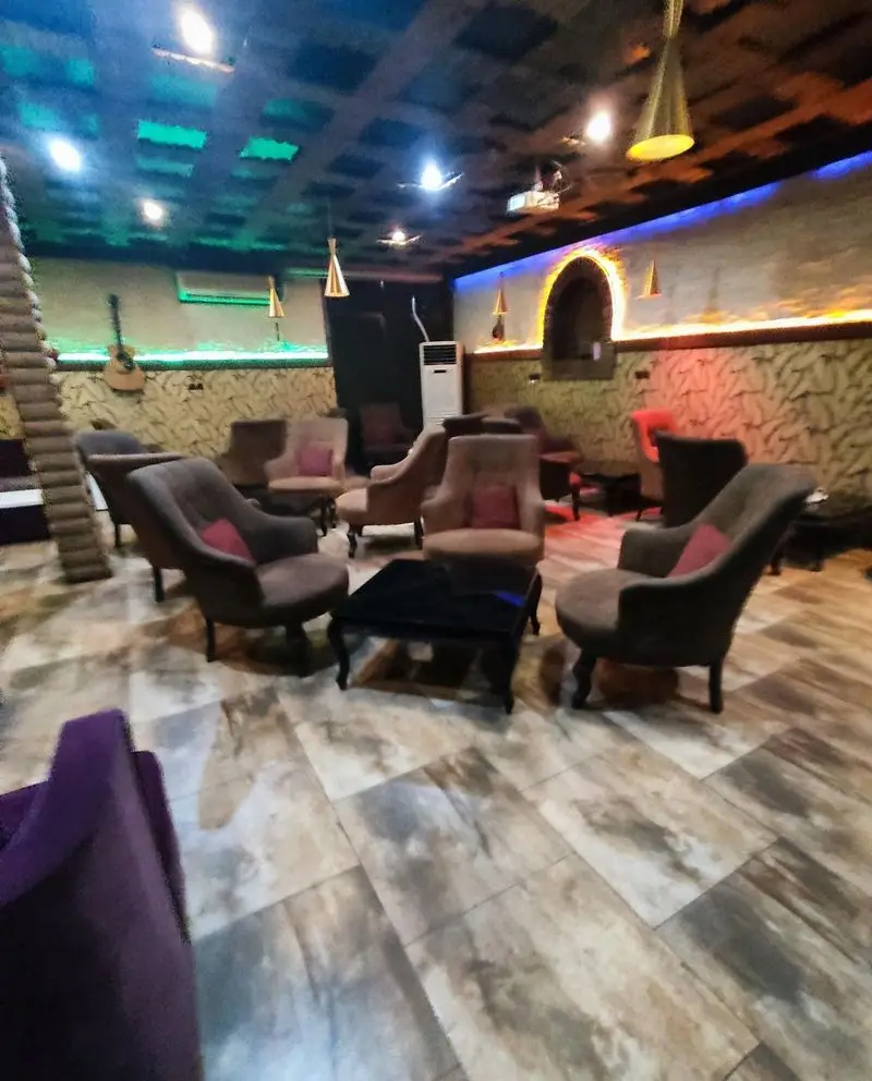 فضای داخلی دنج و دلنشین کافه سنتی ایران زمین، با چیدمان مبلمان راحت، دکوراسیون سنتی-مدرن و نورپردازی جذاب، محیطی عالی برای تجربه دلنشین.