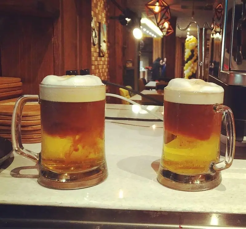 دو ماگ نوشیدنی لایه ای جذاب و خوش‌رنگ با کف خامه ای در کافه رستوران دیاکو. لذت تجربه نوشیدنی‌های خاص در محیطی دلنشین و مدرن.