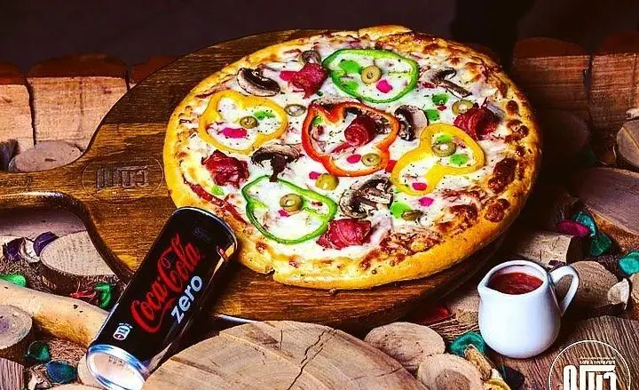 پیتزای لذیذ و پرطرفدار کافه رستوران دیاکو، با فلفل دلمه‌ای رنگی، قارچ و سوسیس، در کنار نوشابه کوکاکولا زیرو؛ یک انتخاب عالی برای فست فود.
