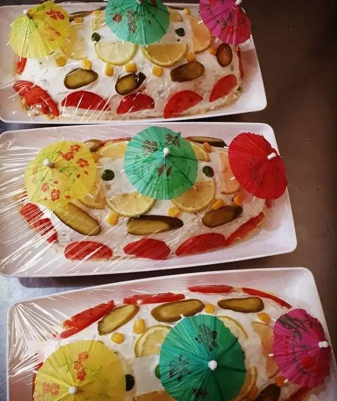 سه سینی سالاد الویه کیکی تزئین شده فست فود بهنام، با برش‌های لیمو، خیارشور، گوجه، ذرت و چترهای رنگی، آماده سرو.
