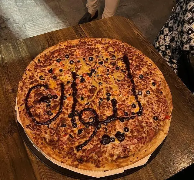 پیتزای بزرگ و سفارشی کافه رستوران لی وان با سس مخصوص و تاپینگ‌های متنوع، مزین به نام "لی وان" برای تجربه‌ای متفاوت و لذت‌بخش.