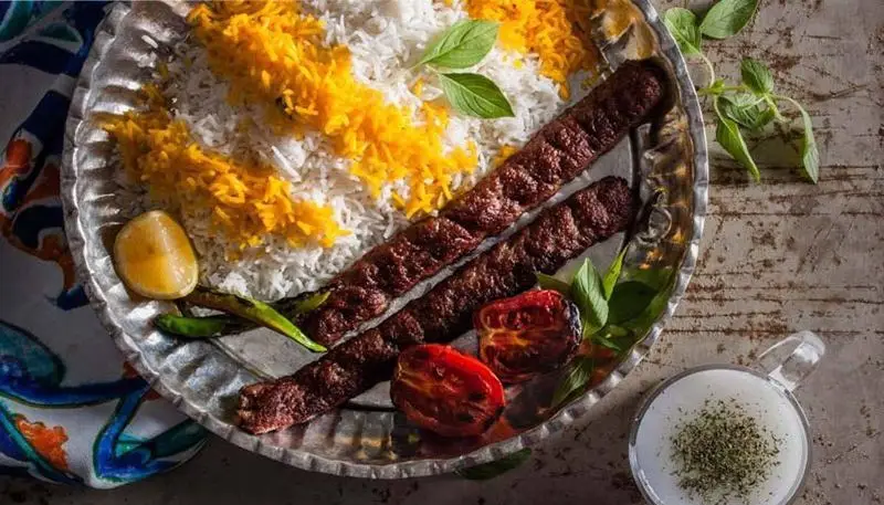 کباب کوبیده لذیذ رستوران طریقت (شریعتی) با برنج زعفرانی، گوجه کبابی و دوغ خنک، تجربه‌ای اصیل از غذای ایرانی.