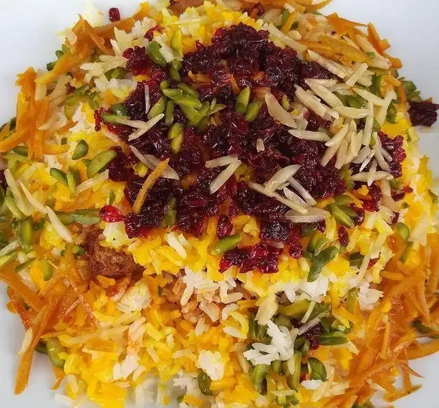پلو مجلسی و زعفرانی رستوران آجی، تزئین شده با زرشک، پسته، خلال بادام و خلال پرتقال. طعم اصیل غذای ایرانی را تجربه کنید.