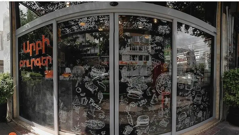 ویترین فست فود آربی برگر با نقاشی‌های جذاب از غذاهای لذیذ مانند برگر، پیتزا، سیب‌زمینی و انواع ساندویچ.