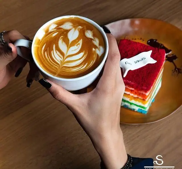 کافه رستوران هفت آسمان: لاته آرت حرفه‌ای و کیک رنگین کمان با روکش مخملی قرمز، تجربه‌ای شیرین از قهوه و دسر را ارائه می‌دهد.