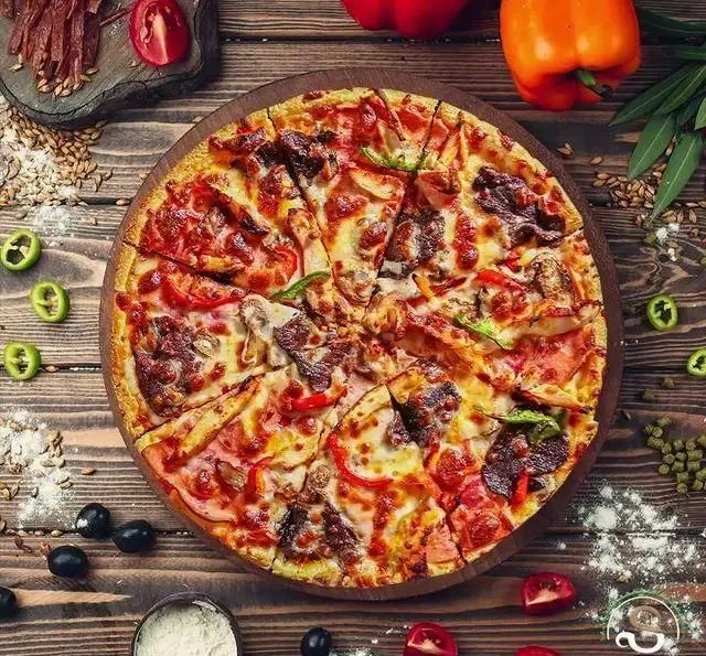 پیتزای بزرگ و تازه کافه رستوران هفت آسمان با گوشت، قارچ، فلفل دلمه‌ای و زیتون روی تخته چوبی. غذای لذیذ منوی فست فود.