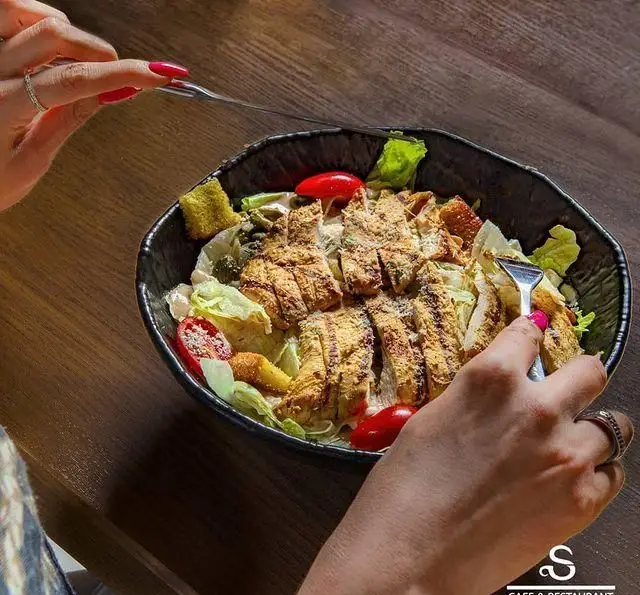 سفارش سالاد سزار مرغ گریل شده با پنیر پارمزان و نان تست در کافه رستوران هفت آسمان برای یک وعده سالم و لذیذ.