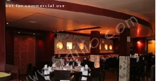 رستوران چینگاری: فضای داخلی بسیار شیک و مدرن با چیدمان میزهای غذاخوری منظم، نورپردازی گرم و دکوراسیون جذاب برای تجربه غذایی دلپذیر.