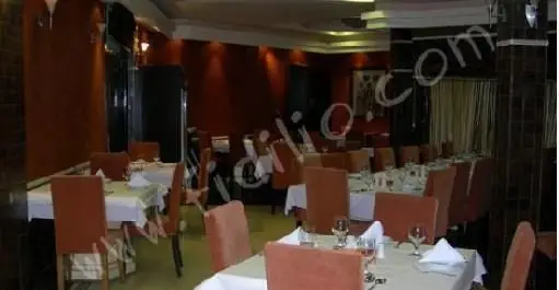 فضای داخلی رستوران نایب با چیدمان شیک میز و صندلی‌های راحت، دیوارهای گرم و نورپردازی دلپذیر، محیطی ایده‌آل برای لذت بردن از غذا.