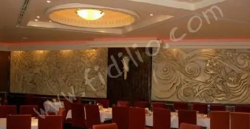 دکوراسیون داخلی مجلل و زیبای رستوران نایب با نورپردازی دلپذیر، سقف طراحی شده و دیوارکوب‌های هنری خیره‌کننده، فضایی شیک برای میزبانی مهمانان.