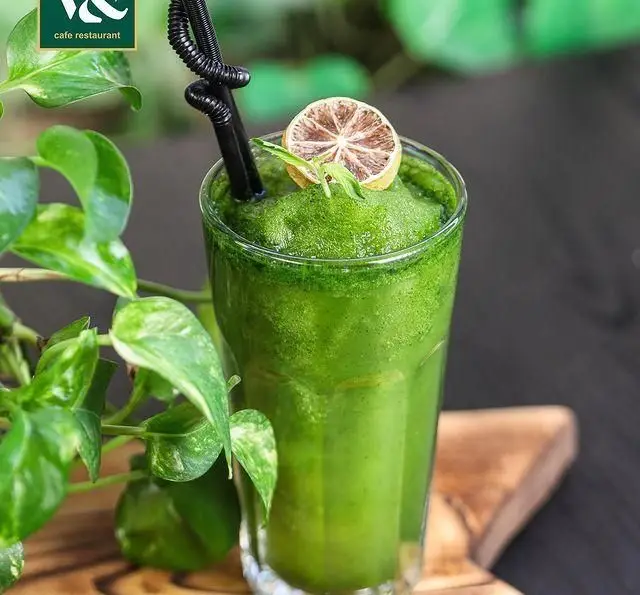 یک لیوان اسموتی سبز گوارا و خنک کافه رستوران ویند با تزئین لیمو خشک و برگ نعنا، ایده‌آل برای سلامتی و تازگی در روزهای گرم.