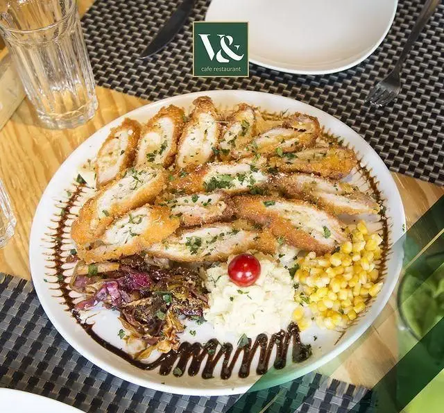 یک بشقاب غذای لذیذ و دلپذیر شامل رول مرغ سوخاری، پوره سیب زمینی، ذرت شیرین و کلم کاراملی شده در کافه رستوران ویند.