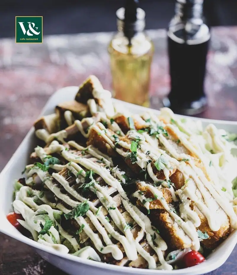 یک غذای اشتهاآور از کافه رستوران ویند: تکه‌های مرغ ترد با سس خامه‌ای مخصوص، سبزیجات تازه و گوجه فرنگی، ایده‌آل برای یک وعده دلپذیر.