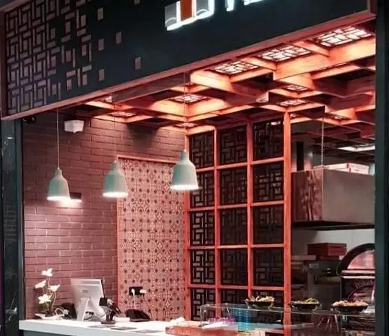 نمای داخلی و شیک فست فود مارونه، با طراحی مدرن شامل سقف چوبی طرح‌دار، دیوارهای آجری و نورپردازی دلپذیر، یک محیط دعوت‌کننده.