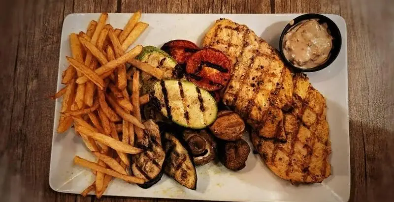 بشقاب مرغ گریل و غذای سالم کافه آگات شامل سیب‌زمینی سرخ‌کرده، سبزیجات گریل شده: کدو، گوجه، قارچ و بادمجان.