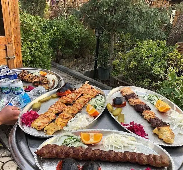 کباب‌های ممتاز جوجه و کوبیده در رستوران بام شهران، سرو شده در محیطی زیبا و فضای سبز دلنشین همراه مخلفات کامل.