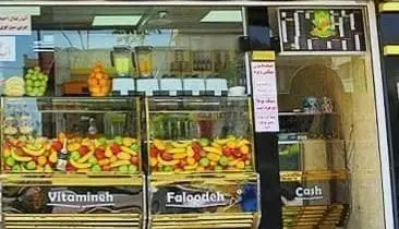 تصویری از مغازه آبمیوه بستنی ویتامینه آریا با انواع میوه‌های تازه مانند موز، توت فرنگی و نوشیدنی‌های ویتامینه.