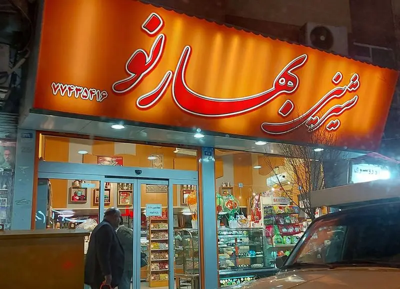 شیرینی فروشی بهار نو: نمای بیرونی این قنادی با تابلو بزرگ و روشن در شب، عرضه کننده بهترین شیرینی، کیک و دسر؛ تلفن ۷۷۳۴۵۹۱۶.