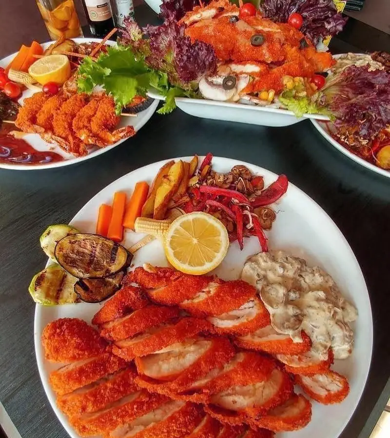 بشقاب کامل شنیتسل مرغ و میگو سوخاری خوشمزه از رستوران فرنگی ویکند. انواع غذاهای لذیذ دریایی و گوشتی.