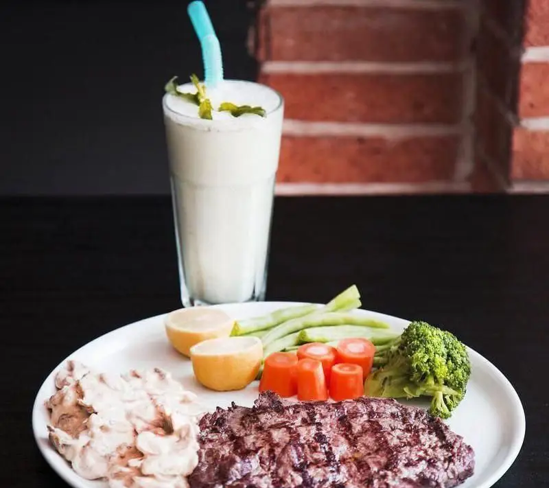 استیک گریل شده آبدار با دورچین سبزیجات تازه شامل هویج، بروکلی و لوبیا سبز به همراه سس قارچ و لیموترش در رستوران فرنگی ویکند.