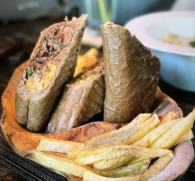 ساندویچ مخصوص گوشت پر شده با نان سبوس‌دار و سیب زمینی سرخ کرده در کافه گالریا. یک وعده غذایی کامل و لذیذ.