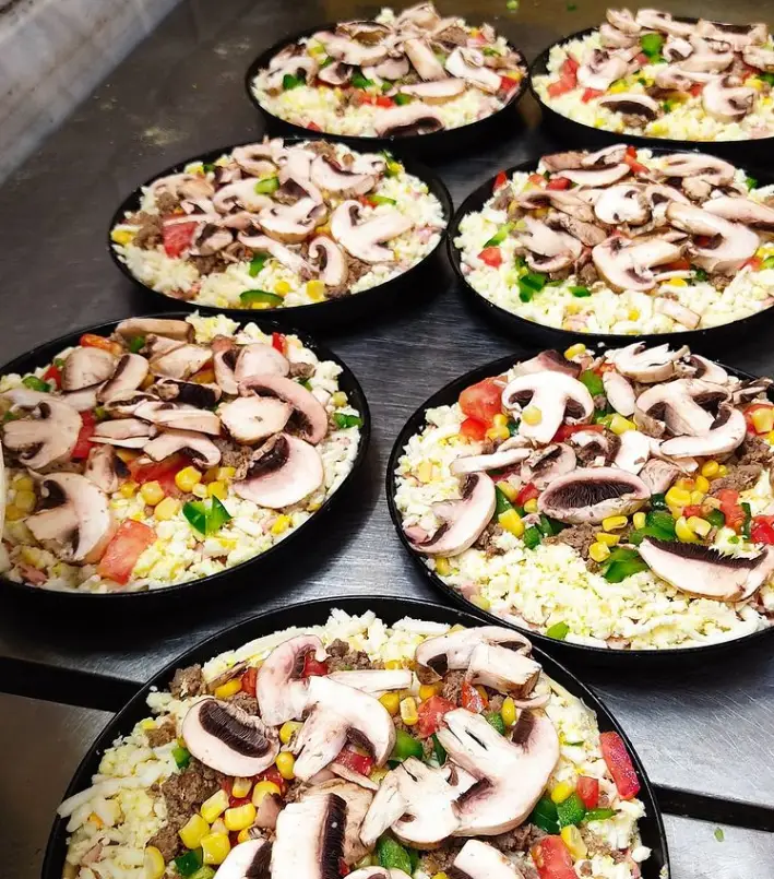 آماده‌سازی پیتزاهای جذاب و پرملات پیتزا ساندویچ رز زرد؛ با قارچ تازه، پنیر، گوشت، فلفل دلمه‌ای، گوجه و ذرت برای پختی عالی.