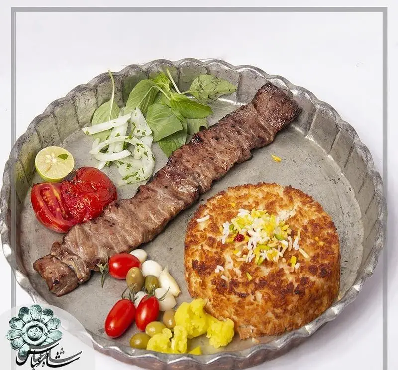 چلو کباب برگ رستوران شاطر عباس با ته دیگ زعفرانی، گوجه کبابی، پیاز، لیمو، زیتون و ترشی. لذت غذای اصیل ایرانی.