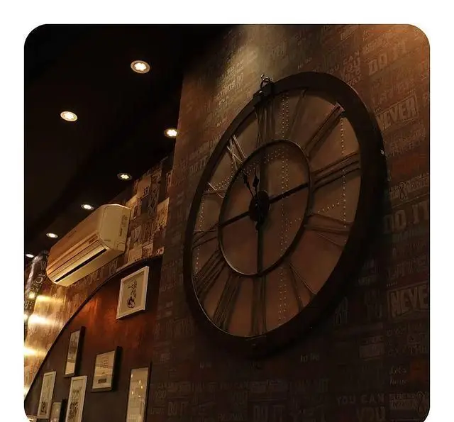 نمایی از دکوراسیون داخلی کافه رستوران توربو شامل ساعت دیواری بزرگ، نورپردازی و قاب عکس‌ها، فضایی دلنشین و شیک.